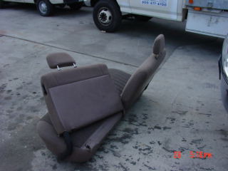 1992 Ford Bronco - A single bench seat is shown outside, with a truck and part of another vehicle in the background. The SuperMotors logo is visible.