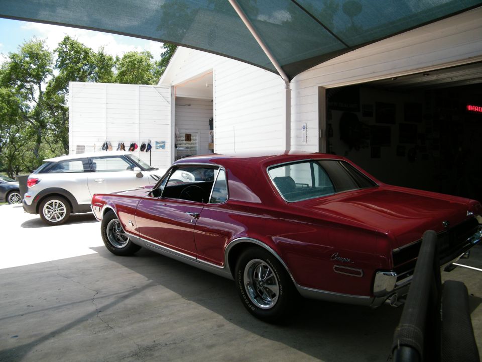 1968 Mercury Cougar coupe, red, parked next to a silver Mini Cooper.