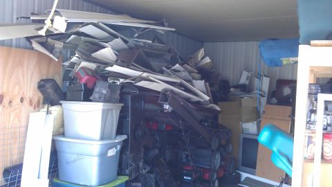 1994 Ford Bronco - A storage unit filled with a large pile of scrap metal and parts, obscuring any view of a 1994 Ford Bronco.
