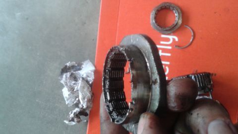 1996 Ford Bronco - A close-up shot shows a disassembled bearing with damaged rollers and grease. The part is held by a hand and lies on an orange surface with…
