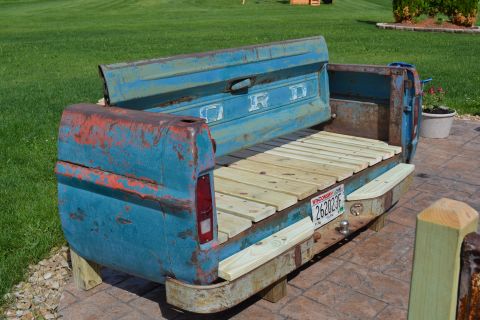 1994 Ford Bronco - A bench made from a vintage truck bed sits on a patio.