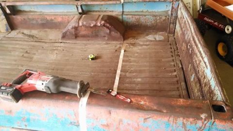 1994 Ford Bronco - The interior of a weathered truck bed shows signs of wear and tear, with tools present.