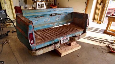 1994 Ford Bronco - A vintage Ford truck bed has been repurposed into a bench, complete with a license plate.