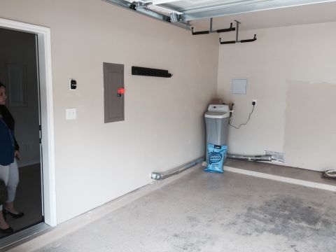 2015 Ford Deluxe - Interior view of a garage, showing a water softener unit, electrical panel, and overhead storage system.