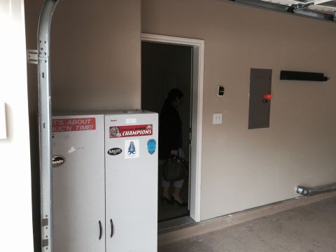 2015 Ford Deluxe - Interior view of a garage space with storage cabinets and a person entering a room.