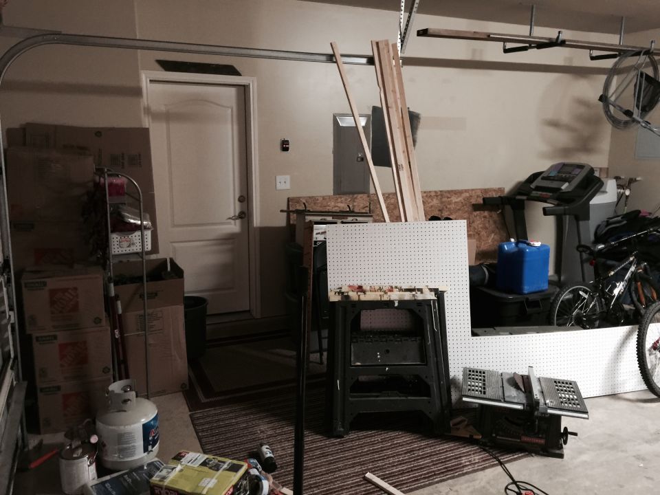 Garage interior with workbench, table saw, treadmill, and bicycle