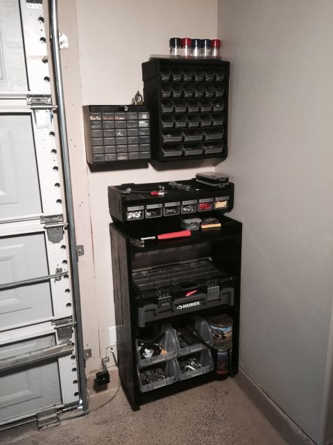 2015 Ford Deluxe - Organized garage storage with various bins and toolboxes holding parts and supplies.