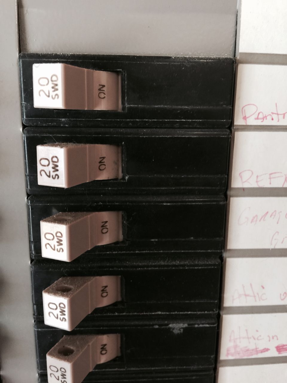 Electrical breaker panel with multiple "20 SWD ON" switches and handwritten labels on the right