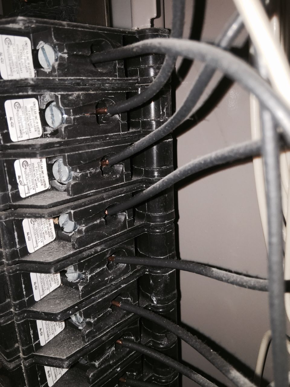 Close-up of an electrical breaker panel with wires connected to multiple breakers