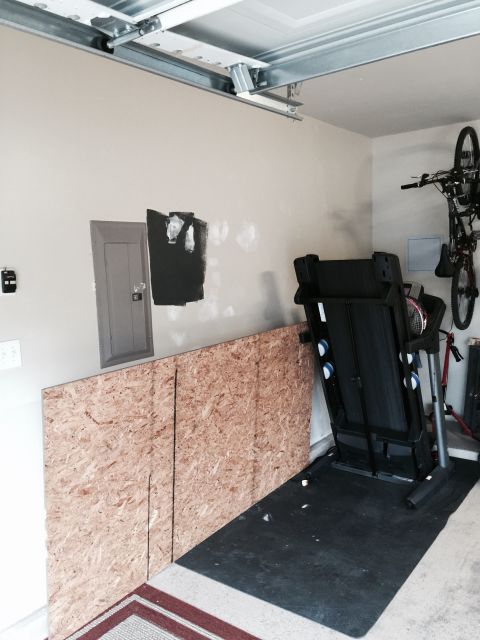 2015 Ford Deluxe - Interior view of a garage containing a treadmill and a bicycle mounted on the wall.