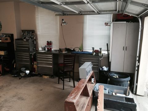 2015 Ford Deluxe - A cluttered garage scene with various tools and storage units visible.