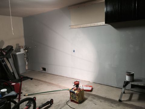 2015 Ford Deluxe - A garage interior scene shows painting supplies and exercise equipment, with a partially painted wall.