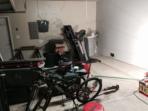 2015 Ford Deluxe - Interior view of a garage containing bicycles, a treadmill, and storage items.