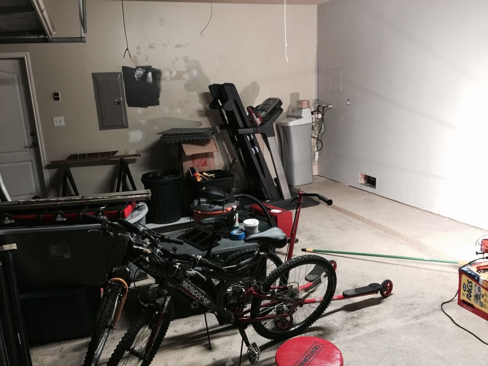 Garage interior with two bicycles, a treadmill, and a water softener unit