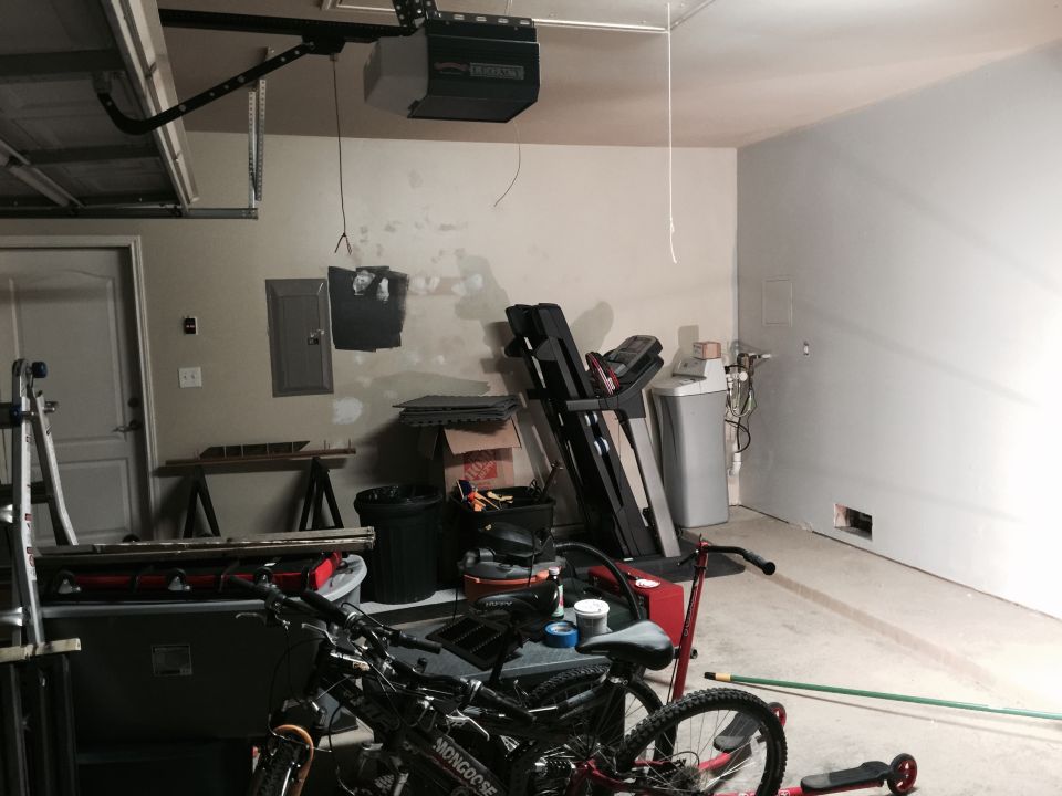 Garage interior with a treadmill, water heater, and two bicycles in the foreground