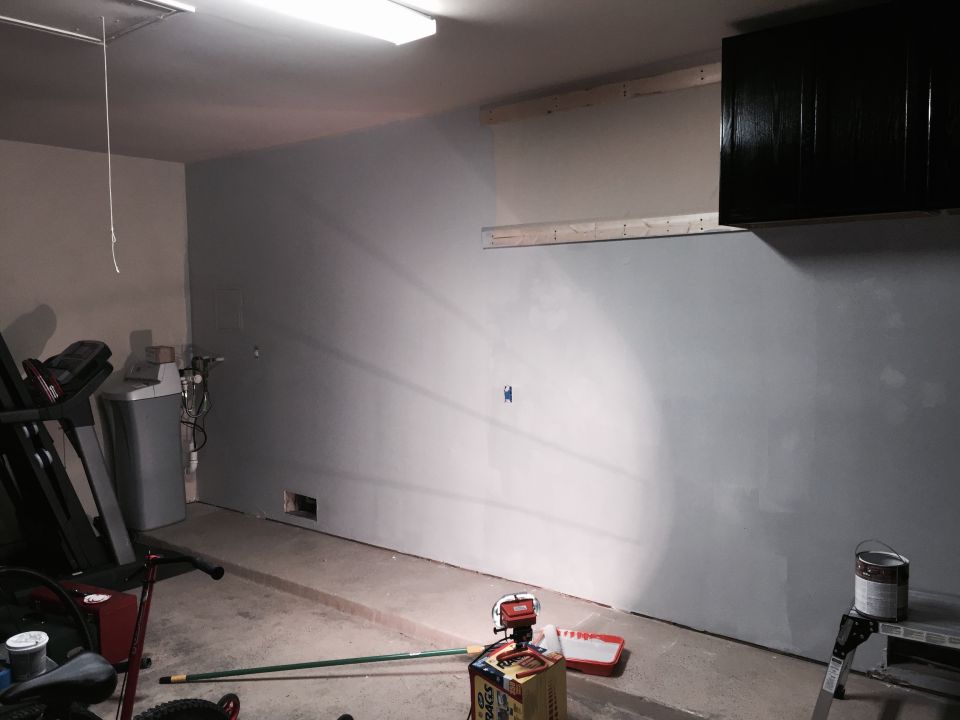 Garage interior with treadmill, water softener, and painting supplies