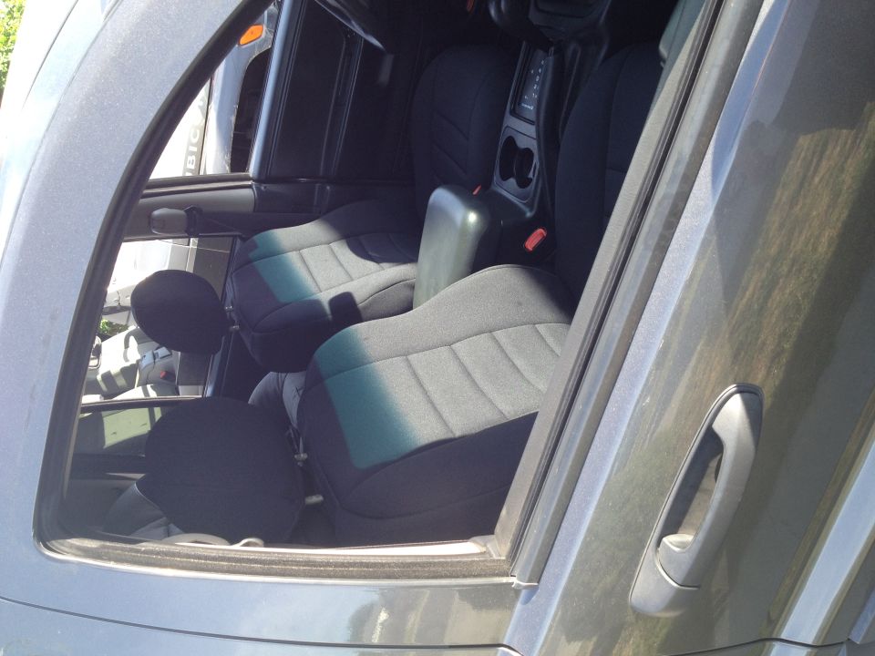 Interior shot of front seats and center console. Another vehicle is visible through the driver's side window