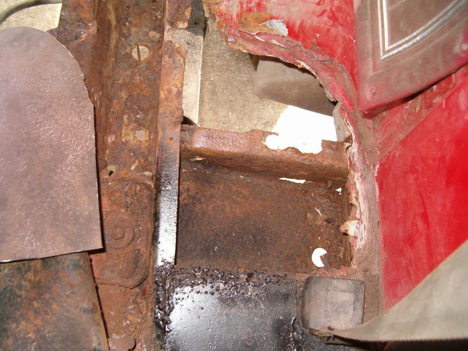 Close-up of heavily rusted metal frame and body panels of a vehicle