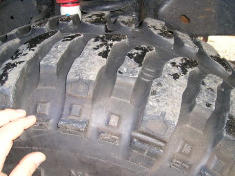 1994 Ford F-150 - A close-up view of the deep tread pattern on an off-road tire, showing wear and embedded debris.