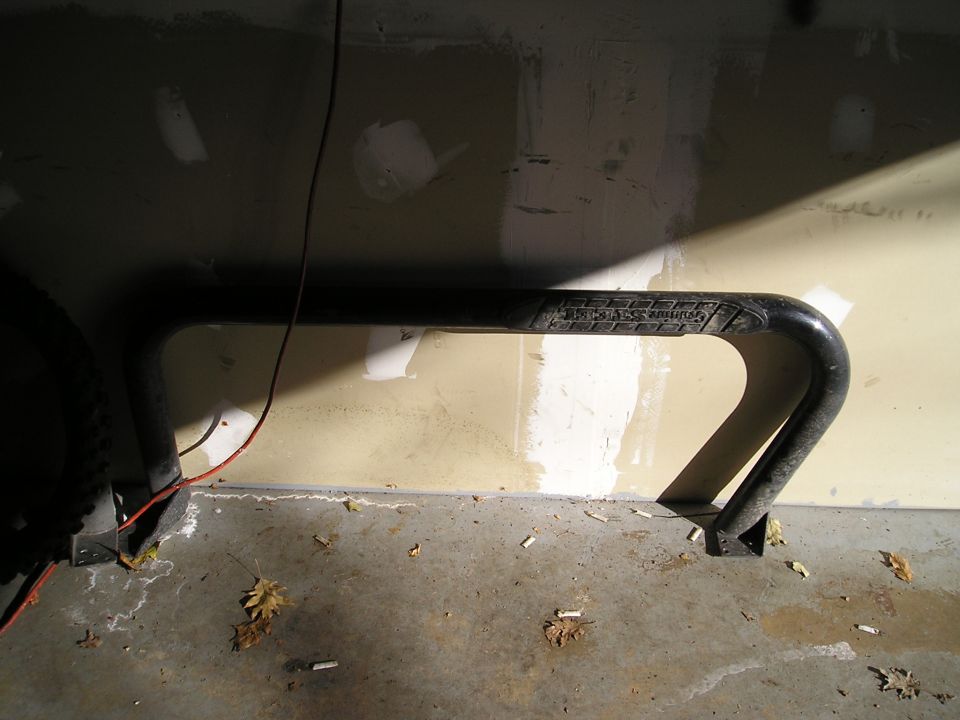 Black metal object with text, mounted to a wall in a garage