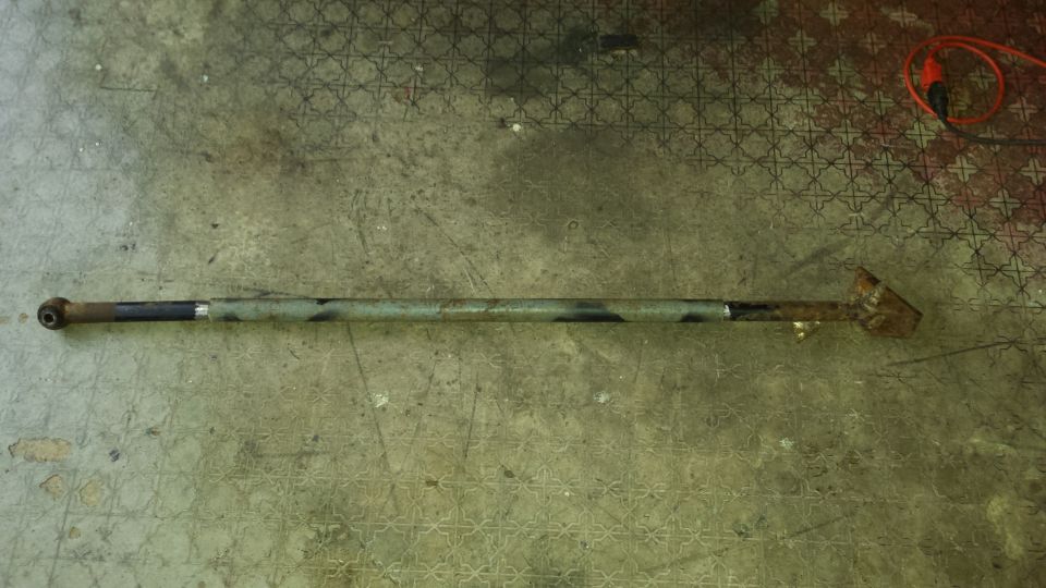 Metal rod with jointed end and welded triangular piece on patterned floor