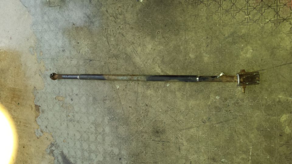 Rusty metal rod with ball joint and bracket on concrete floor