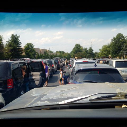 1978 Ford Bronco - A line of parked cars in a parking lot with people walking between them. The photo is taken from the perspective of someone inside a vehicl…