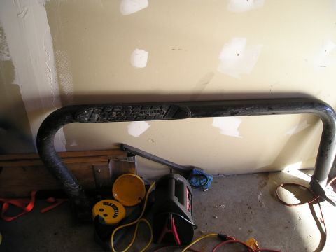 1994 Ford F-150 - A black nerf bar, likely for a truck, is shown indoors with various tools and accessories on the floor.