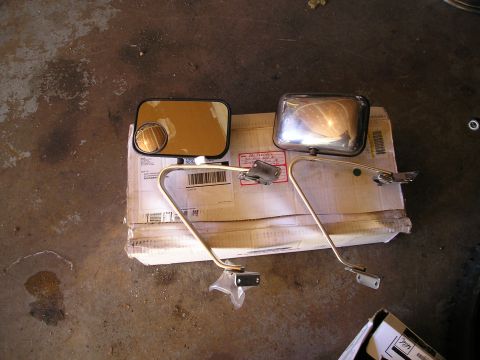 1994 Ford F-150 - A pair of side mirrors, one with a chrome finish and the other with a black frame, are displayed on a cardboard box.