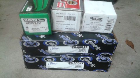 1996 Ford Bronco - Several automotive parts boxes are stacked on a concrete surface. Visible boxes include Hawk HB295 Y.630 brake pads, a Warn part number 209…