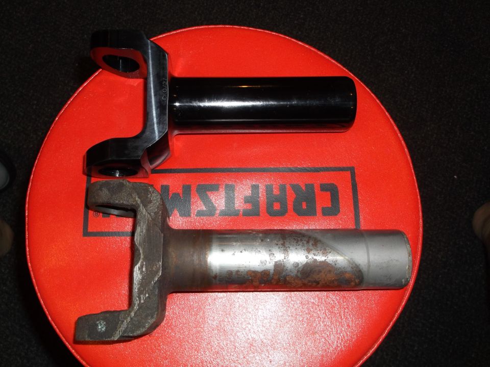 Comparison of a new black driveshaft yoke and an old rusted yoke.