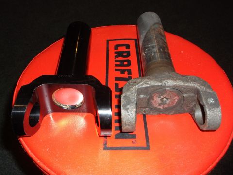 1999 Mercury Grand Marquis - A new black yoke with a red insert is shown next to an old, rusted yoke on a red circular surface with black lettering. The new yoke has "C…