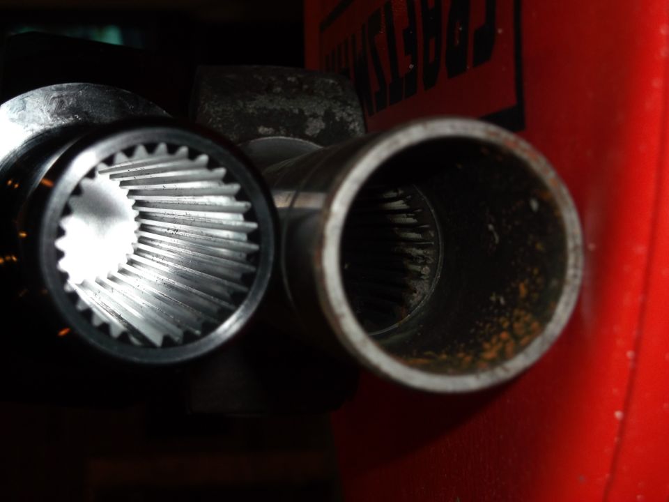 Close-up of two splined metal shafts, one clean, one rusty.