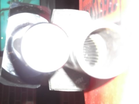 1999 Mercury Grand Marquis - A close-up, overexposed view of two metallic cylindrical parts, possibly exhaust tips or suspension components, with one showing internal s…