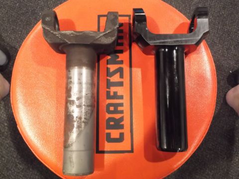 1999 Mercury Grand Marquis - Two driveshaft yokes are shown side-by-side on an orange Craftsman stool. The yoke on the left appears to be older and shows signs of rust…