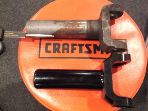1999 Mercury Grand Marquis - driveshaft slip yoke and a steering column shaft laid out on an orange Craftsman tool tray with a digital caliper nearby.