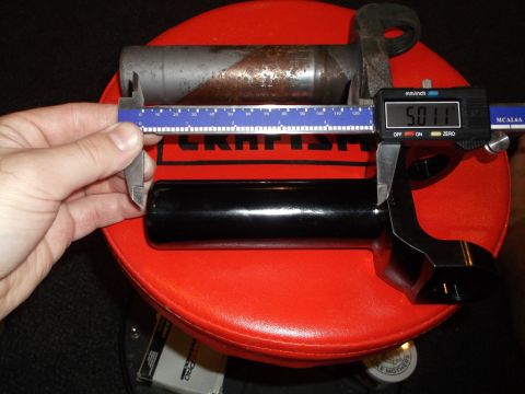 1999 Mercury Grand Marquis - A digital caliper measures the diameter of a black cylindrical part, reading 5.011 inches. The part rests on a red circular surface, possib…