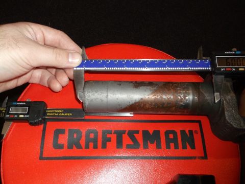 1999 Mercury Grand Marquis - A hand holds a caliper measuring a metal cylinder. The cylinder is placed on a red Craftsman tool case.