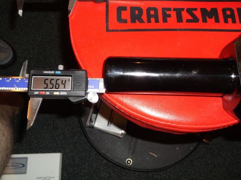 1999 Mercury Grand Marquis - A digital caliper measures the diameter of a black cylindrical object, displaying a reading of 5.564 inches. The object rests on a red Craf…