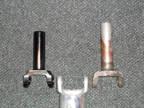 1999 Mercury Grand Marquis - Two metal yokes are shown against a grey carpeted background. The yoke on the left is black and appears to be in good condition, while the…