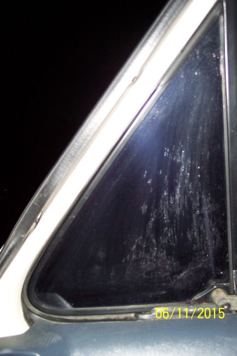 1990 Ford Bronco - A close-up view of a triangular car window with water droplets and streaks on the glass. A date stamp of "06/11/2015" is visible in the low…