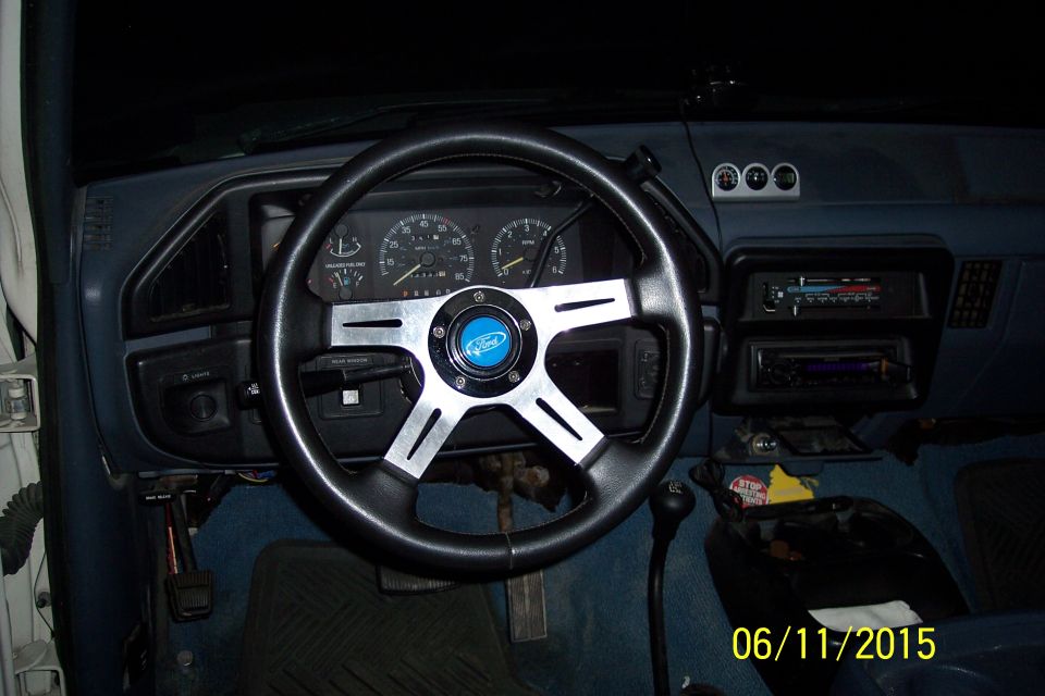 Interior of a Ford Bronco with custom steering wheel and dashboard.