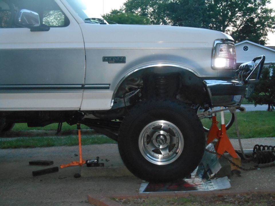 1994 Ford Bronco driver's side, lifted on jack stands, front wheel off.
