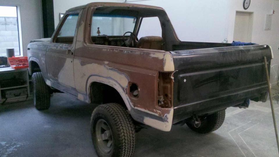 1982 Ford Bronco rear passenger side, brown and black two-tone, primer visible