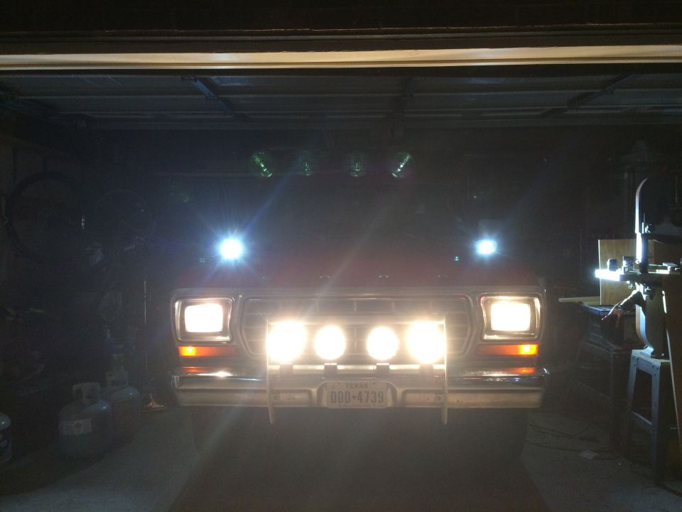1979 Ford Bronco with auxiliary lights on, parked in a garage.
