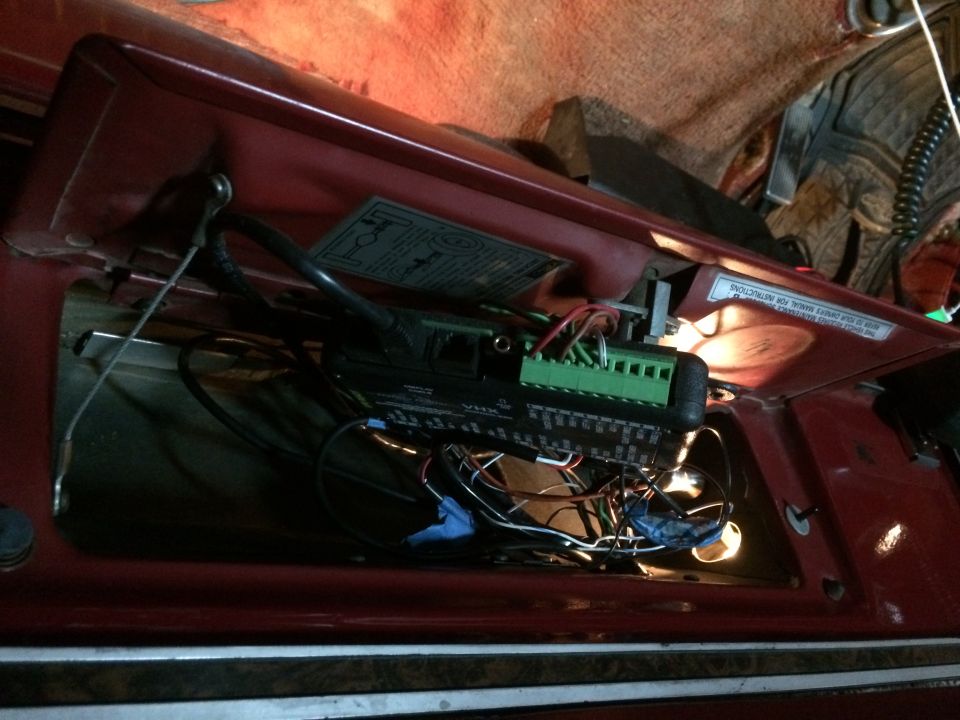Close-up of vehicle interior electronics with wiring and a green terminal block.