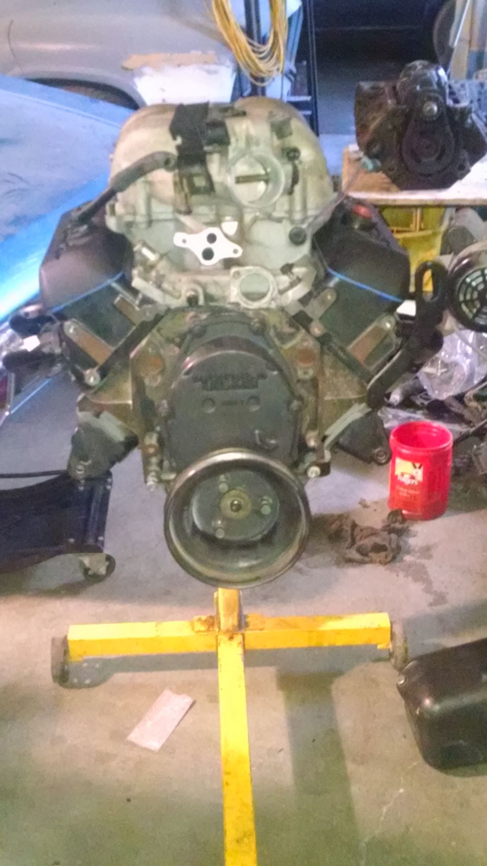 V8 engine on yellow stand, front view, showing pulley