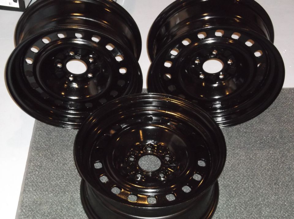 Three black steel wheels with a multi-hole design.