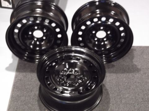 1999 Mercury Grand Marquis - Three black steel wheels are arranged in a cluster. The wheels have a simple design with multiple circular holes around the rim.