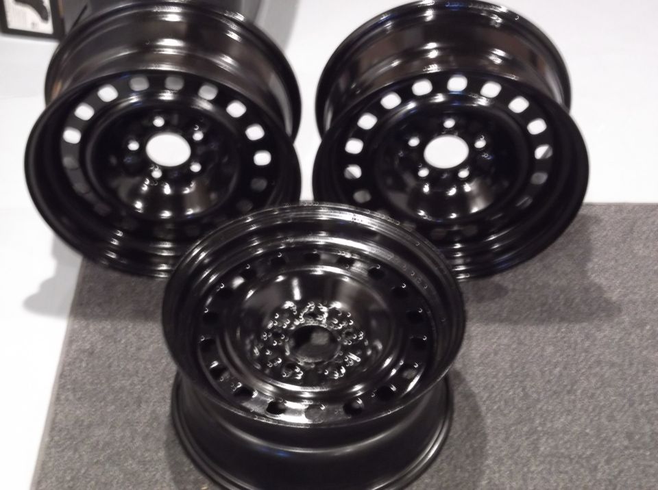 Three black steel wheels with circular holes.